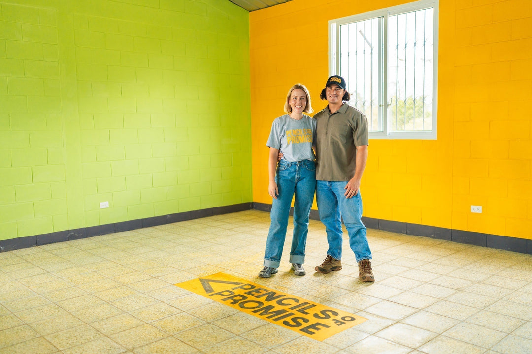 Christian and Anna of Air Plant Shop standing inside a Pencils of Promise classroom in Guatemala